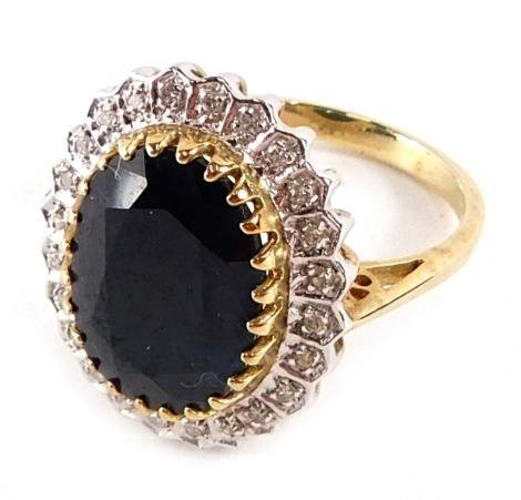 A 9ct gold cluster ring, the central oval black stone in rub over setting, surrounded by tiny diamonds to pave setting, in white gold and yellow metal band, ring size O½, 4.6g all in.