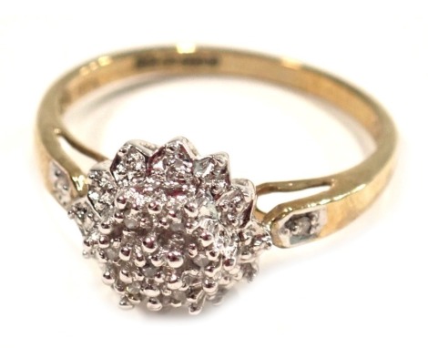 A 9ct gold diamond cluster ring, the raised flora cluster set with tiny diamonds, totalling 0.05ct, with a raised basket and V splayed shoulders, ring size P, 2.4g all in.