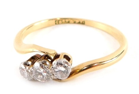 A Victorian three stone dress ring, set with three round brilliant cut diamonds, each in platinum claw setting, with a twist ring head, yellow metal stamped 18ct plat, ring size L, 2.1g all in.