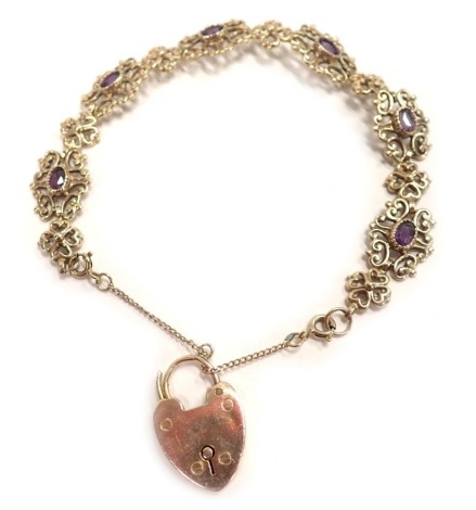 A 9ct gold gate bracelet, floral scroll design, set with oval amethyst, with extender chain and heart shaped padlock, 22cm long, 15g all in.