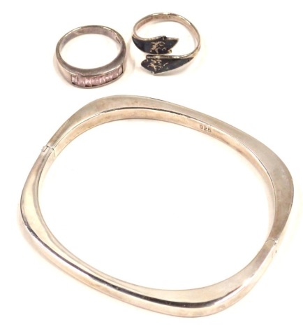 A shaped bangle, white metal stamped 925, and two white metal dress rings, one stone set, one of eastern design, each stamped 925, 16.1g all in. (2)