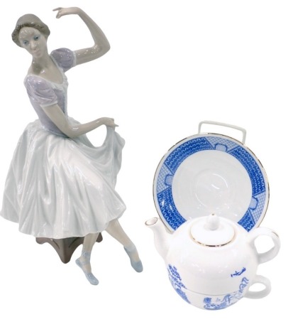 A Lladro figure of a lady seated in flowing dress, 33cm high, and a Lincoln Cathedral by Pyramid Pottery tea for one set. (2)