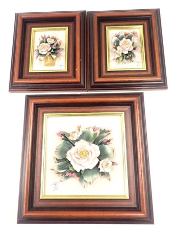 Three Capodimonte floral plaques, comprising a square example with pink roses, 16cm x 16cm, and two smaller basket examples, 10cm x 7cm, framed. (3)