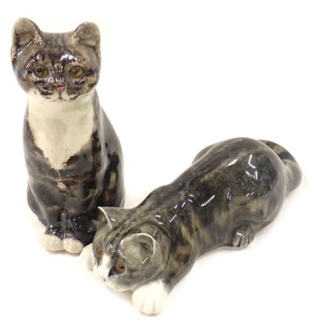 Two Mike Linton ceramic cats, comprising seated tabby with amber eyes, 20cm high, and pouncing tabby, 21cm wide. (2)