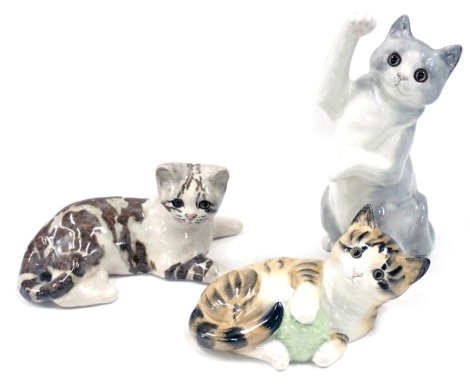 Three Winstanley and Hinton ceramic cats, comprising grey leaping cat, 29cm high, seated mottled cat, 20cm wide, and a ginger cat with wool ball, 21cm wide. (3)