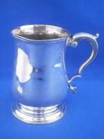 A George III silver baluster shaped mug with a scroll handle