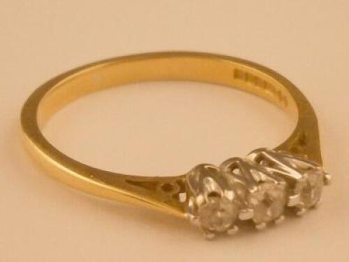 A three stone tiny diamond set ring in 18ct gold setting