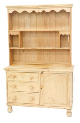 A Victorian pine dresser, the associated back with a moulded cornice and shaped apron, two shelves with recesses, the base with a moulded edge above three drawers and a door, on turned legs, 122cm wide.