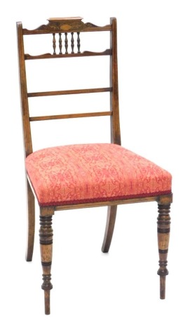 A late Victorian rosewood side chair, the rail back with spindle turned supports above a padded seat, on turned tapering legs.