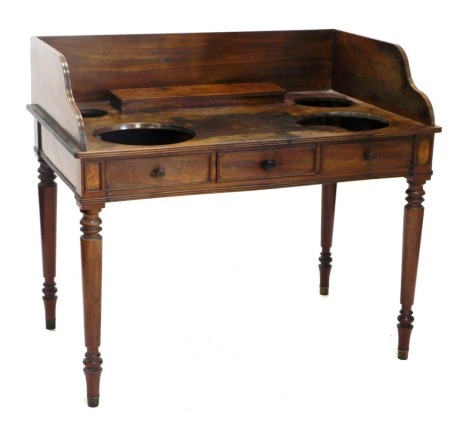 An early 19thC mahogany washstand, in the manner of Gillows, the raised back and recesses for bowls, and a hinged recess for soaps, etc., above a single frieze drawer, on turned tapering legs, 93cm high, 107cm wide, 70cm deep.