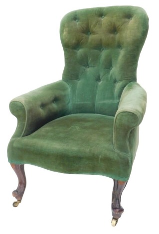 A Victorian mahogany button back armchair, upholstered in green fabric, on cabriole legs with brass castors.