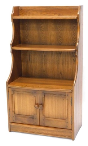 An Ercol style elm side cabinet, with two bowed doors and two panelled doors, on a plinth, 111cm high, 61cm wide.