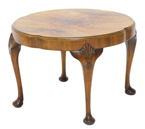 An early to mid 20thC walnut and beech coffee table, the circular quarter veneered top with a lobed edge on cabriole legs carved with shells, 60cm diameter.