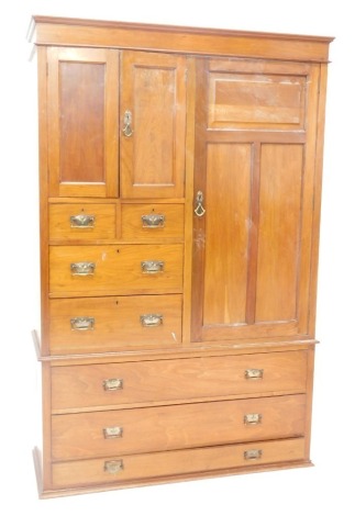 A late 19thC walnut wardrobe, with a moulded cornice above an arrangement of a long panelled door, two small doors, two short and two longer drawers, and three long drawers to the base, possibly lacking feet, 206cm high, 114cm wide.