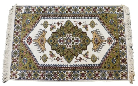 A Turkish rug, with a central green, yellow, pink and cream pole medallion, on a cream ground with green pattern spandrels, on wide border, 97cm wide, 140cm long.