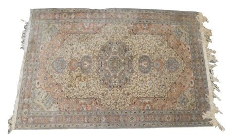 An Indian style small carpet, decorated with a design of coloured medallions in pink, purple, etc., on a beige ground with one wide and two narrow borders, 286cm x 199cm.