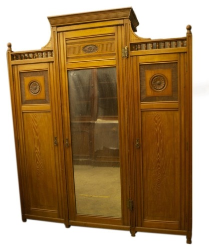 A late Victorian aesthetic movement light ash wardrobe compactum and dressing table by Shapland & Petter, the wardrobe having centre moulded cornice and gallery sides, the central fitted mirror door having press drawers over three solid and flanked by ros