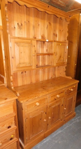 A pine dresser, with plate rack over two doors, over three drawers above three doors raised, on plinth base.