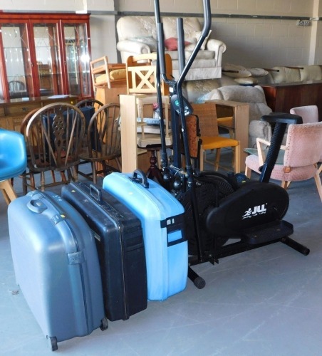 An exercise machine and three suitcases.