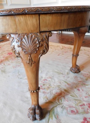 A George II style walnut extending dining table, the oval burr top with a carved edge, raised on four shell and scroll carved legs with raised beading, on hairy paw feet, 75cm high, the top 121cm x 150cm, with winder, together with a set of ten Queen Anne - 2