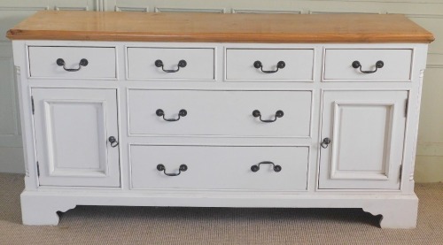 A modern pine and cream painted sideboard, the top with a moulded edge above four short drawers above two longer drawers flanked by panelled cupboards, on bracket feet, 92cm high, 176cm wide, 46cm deep.