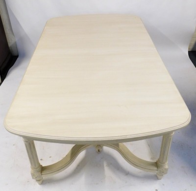 A 20thC Continental cream painted extending dining table, the rectangular rounded top with a moulded edge above cylindrical fluted legs with carved decoration, united by shaped stretchers, 78cm high, the top 210cm x 123cm, with two additional leaves, each - 2