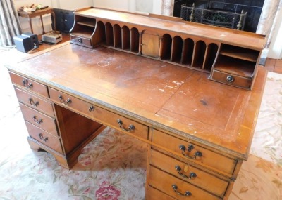 A 20thC yew desk, the raised top with an arrangement of recesses, central cupboard and drawers, etc., with a gilt tooled leather inset above a central frieze drawer flanked by two four drawer pedestals, on bracket feet, 105cm high, 152cm wide, 92cm deep. - 2