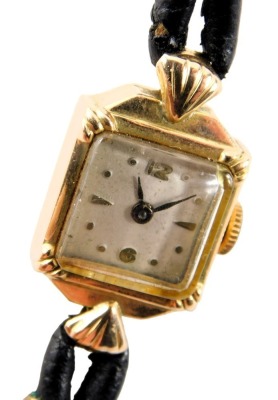 A 9ct gold cased lady's cocktail watch, with a square dial with silvered backing and black hands, 1cm diameter, on a two strand black leather strap, 9g all in.