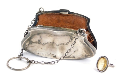 A Victorian or Edwardian silver coin purse, enclosing a brown leather concertina section, with metal chain and finger ring, Chester hallmarks rubbed, 8cm wide, together with a faceted stone set silver ring. (2)