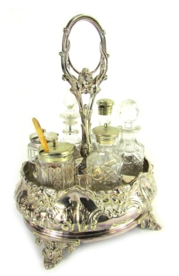 A late Victorian silver plated cruet, with central ring handle and six sections for bottles, the base of oval form embossed with foliate and fruit decoration, on four scroll cast feet, together with six bottles and jars, the stand 29cm high.