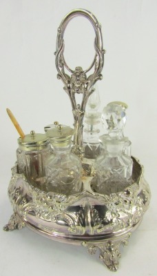 A late Victorian silver plated cruet, with central ring handle and six sections for bottles, the base of oval form embossed with foliate and fruit decoration, on four scroll cast feet, together with six bottles and jars, the stand 29cm high. - 2