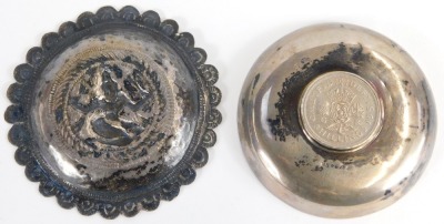 An Indian white metal trinket dish, of circular form engraved with leaf motif decoration, inset centrally with a George VI 1951 two shilling coin, 7.5cm diameter, together with an Eastern white metal trinket dish of circular form with petalated border, em - 2