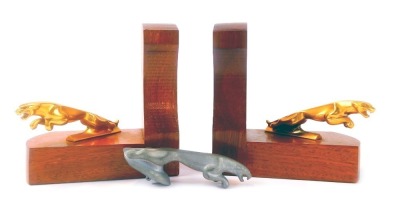 A pair of 20thC oak Jaguar car L shaped bookends, each mounted with a brass cast metal figure of a jaguar mascot, 17cm high, together with a similar cast metal jaguar, 13cm long.