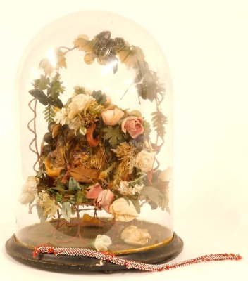 A late 19thC wax and material fruit centrepiece, formed as a still life with central nest and flowers and fruit design, on a black ebonised base with glass dome, 43cm high. (AF) - 2