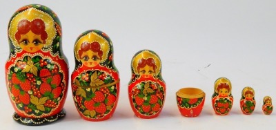 A Russian Matryoshka nesting doll, decorated with fruit against a red and black ground, 19.5cm high. - 2