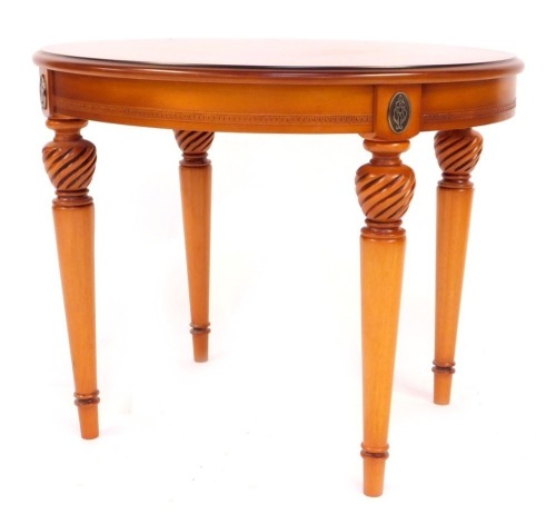 A French Empire style walnut oval table, on turned and tapered legs, 53cm high, 65cm wide, 56cm deep.