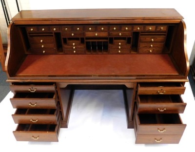 A 20thC oak roll top desk, the tambour front enclosing a dark red leatherette inset with an arrangement of drawers, recesses, etc., the base with a moulded edge above two pedestals each with four drawers, on a plinth base, 127cm high, 183cm wide, 76cm dee - 3