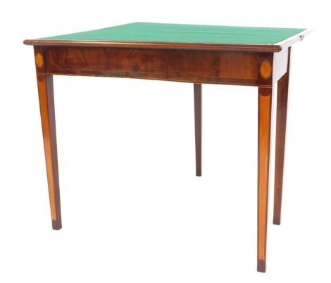 A George III mahogany and line inlaid card table, the hinged lid enclosing a green felt interior, each corner decorated with oval paterae on square tapering legs inlaid with satinwood and ebony, 74cm high, 86cm wide, 43cm deep when closed.