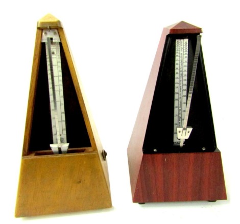 A Maezel Paquet oak cased metronome, 24cm high, bearing label for Paquet Made in France, and another. (2)