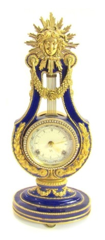 A Victoria and Albert Museum porcelain and brass Marie Antoinette mantel clock, the circular astrological dial bearing Roman numerals, eight day movement, the blue glazed porcelain lyre case with gilt metal mounts, 38cm high.