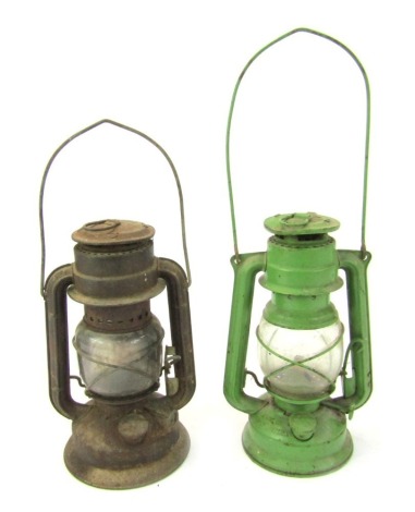 A Czechoslovakian green painted paraffin lamp, numbered 863, 25cm high, and another similar, 24cm high. (2)