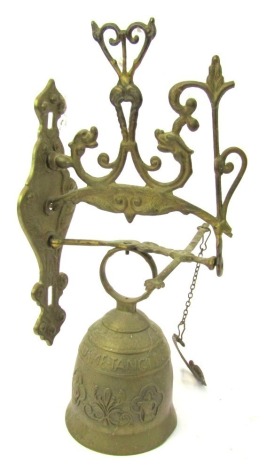 A 20thC wall mounted brass bell, the bell decorated with figures and scroll motifs, on a pierced scroll work bracket, the bracket 29cm high.