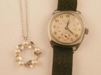 A vintage Rotary gent's wristwatch in a steel case with fabric strap and a white metal pendant and n