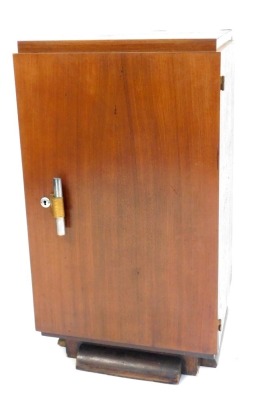 An Art Deco rosewood canteen cabinet, the hinged door enclosing five drawers, with compartments for cutlery, above a recess, raised on a shaped base, 90cm high, 50cm wide, 40cm deep.