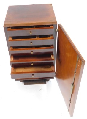 An Art Deco rosewood canteen cabinet, the hinged door enclosing five drawers, with compartments for cutlery, above a recess, raised on a shaped base, 90cm high, 50cm wide, 40cm deep. - 2