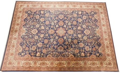 A Persian style machine woven rug, blue ground, decorated centrally with floral and leaf motifs, within multiple borders. 249cm x 359cm