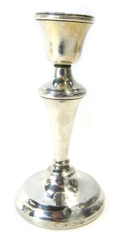 A George V silver candlestick, on a tapering base, loaded.