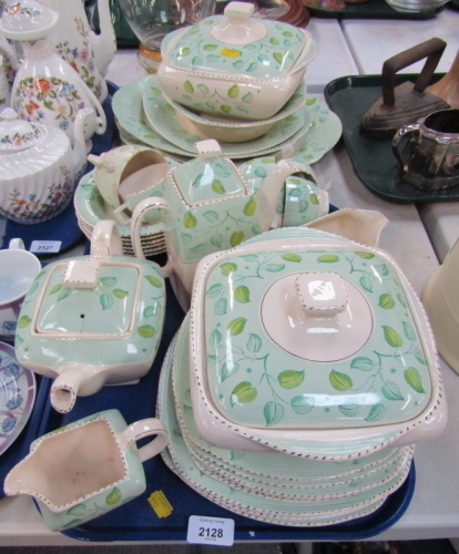 A Burleigh ware pottery part tea and dinner service, on a cream ground with green floral pattern, to include graduated meat plates, tureens, serving plates, cups and saucers, soup bowls, teapot, coffee pot, etc. (1 tray plus)