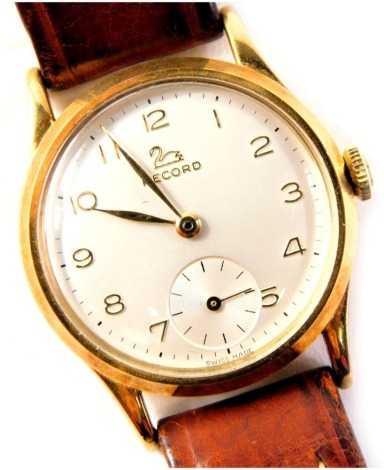 A Record 9ct gold cased gent's wristwatch, with a silvered numeric dial, second subsidiary dial and gold hands, the dial 2.5cm wide, on a brown leather strap, 30.8g all in.