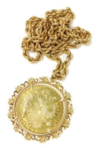 An Austrian gold 4 carat coin 1915, restrike, the obverse with the laureate head of Emperor Franz Joseph I, reverse with the Imperial coat of arms, with crowned, double headed eagle, in a yellow metal pendant mount, on a rope twist neckchain, the oval lin